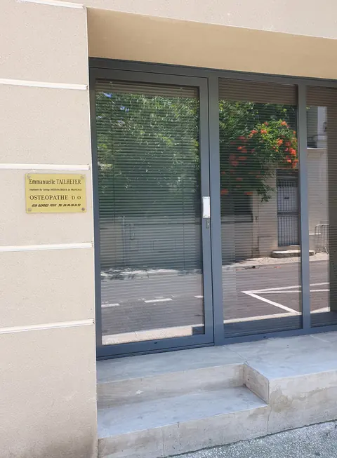 Entrée du cabinet d'ostéopathie, 16 rue Monjardin à Nîmes : porte vitrée à droite de la plaque professionnelle